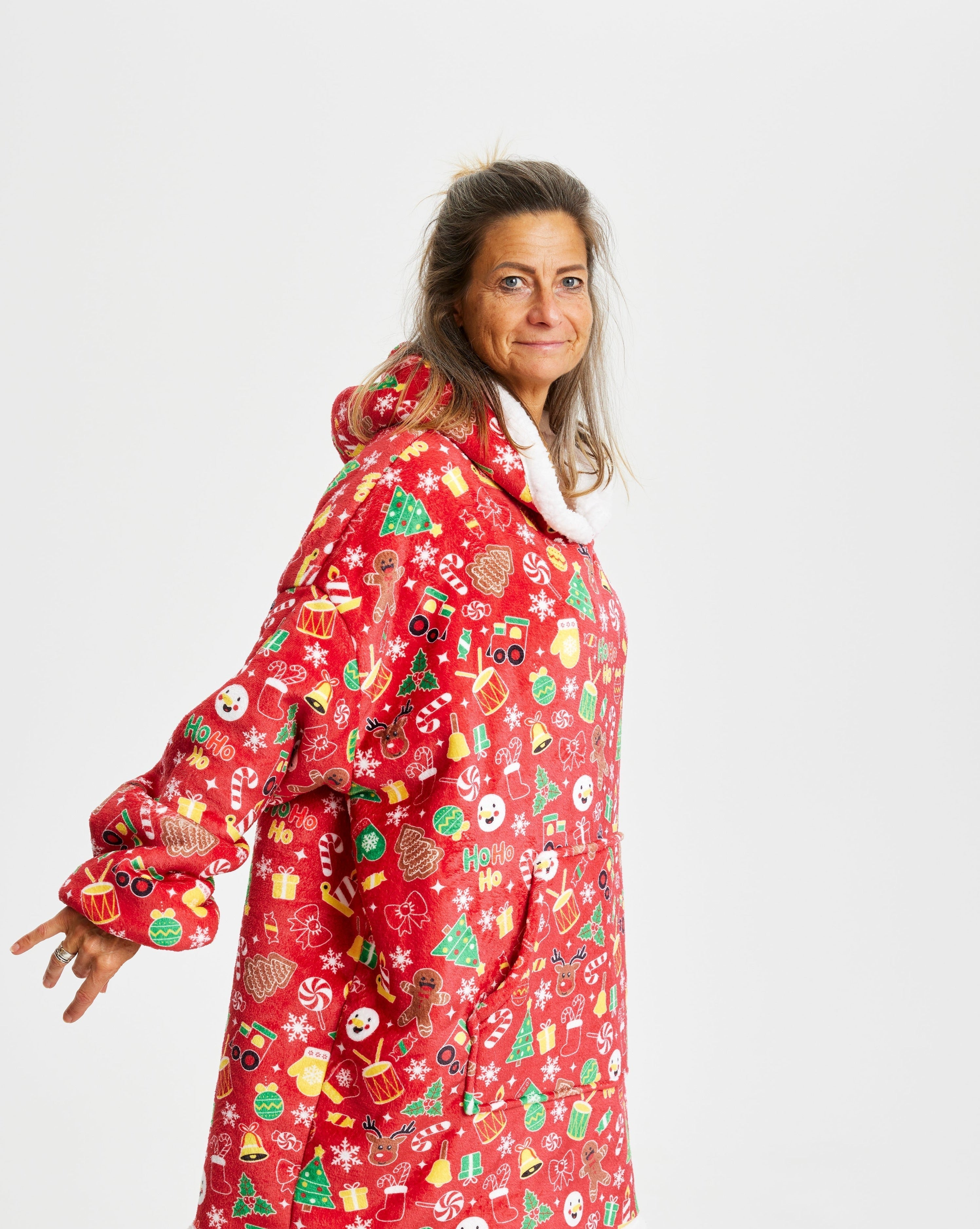 Een glimlachende vrouw die een rode kerstmuts draagt.